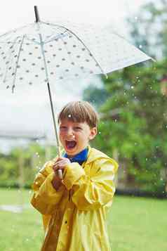 雨使快乐肖像快乐的男孩站伞多雨的一天
