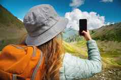 女孩拍摄电话风景如画的的观点山森林毛茸茸的云徒步旅行
