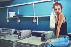让清洁肖像有吸引力的年轻的女人坐着洗机持有漂白剂洗洗内部洗衣房间一天
