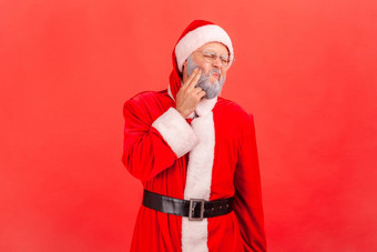 肖像生病的上了年纪的男人。灰色的胡子穿圣诞老人老人服装站触碰脸颊痛苦可怕的牙痛