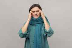女人站包装围巾感觉头疼冷症状流鼻涕的鼻子皱着眉头脸