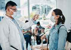 科维德旅行医生采取温度女人穿面具机场安全流感大流行医疗保健专业红外温度计旅行协议