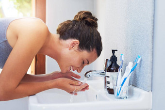 护肤品每天承诺有吸引力的年轻的女人洗脸浴室
