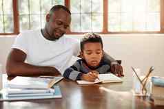 监督重要的英俊的年轻的父亲帮助儿子家庭作业