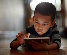 探索世界应用程序年轻的男孩数字平板电脑说谎地板上首页