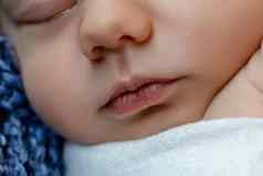 新生儿婴儿脸特写镜头睡觉新生儿男孩白色针织毯子谎言蓝色的皮毛