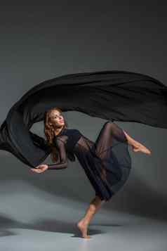 跳舞女人黑色的衣服当代现代跳舞灰色的背景