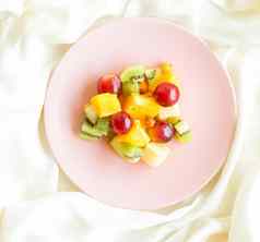 多汁的水果沙拉丝绸平铺健康的生活方式早餐床上概念