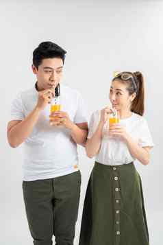 年轻的漂亮的亚洲夫妇眼镜橙色汁