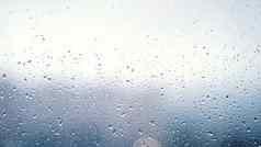 关闭视图水滴下降玻璃雨运行窗口多雨的季节秋天雨滴细流灰色天空