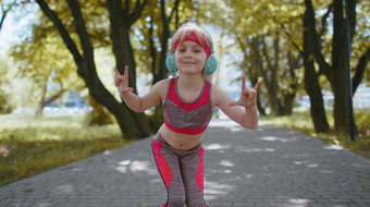 体育运动跑步者孩子女孩培训锻炼听音乐耳机跳舞相机有趣的