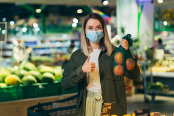 年轻的女人脸医疗保护面具选择选择生态袋蔬菜水果