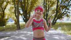 运动健身体育运动跑步者孩子女孩走智能手机听音乐耳机