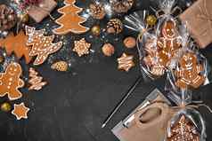 圣诞节姜饼饼干形状圣诞节树玻璃纸包装背景黑暗表格圣诞节礼物概念