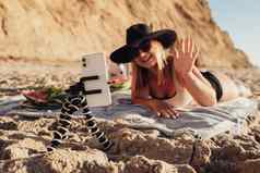 智能手机附加三脚架焦点年轻的女人拍摄移动相机享受假期海