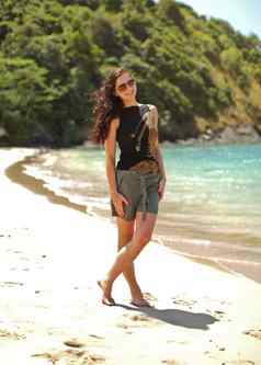 年轻的苗条的女人黑色的衬衫短裤穿太阳镜风黑暗头发站海滩Azure海洋背景KOHlanta泰国