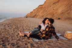 年轻的夫妇接吻海滩黎明女人男人。会议日出海风景优美的海岸线背景