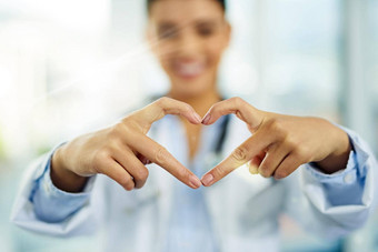 最大的财富投资健康肖像年轻的女医生使心形状手指