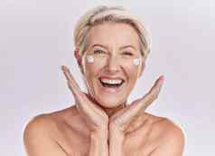 护肤品快乐高级女人微笑健康美脸工作室背景肖像成熟的女模型健康的健康皮肤护理奶油防晒霜