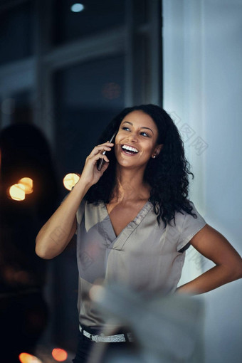 笑声晚些时候转变年轻的女商人会说话的移动电话晚些时候晚上工作