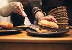 订单特写镜头面目全非,厨师纹身手服务汉堡板内部厨房餐厅