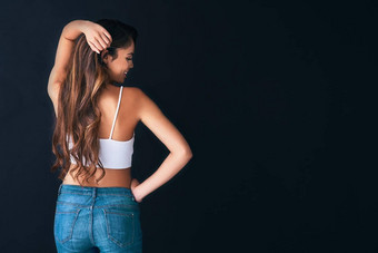 停止触碰大量的健康的头发工作室拍摄有吸引力的年轻的女人摆姿势黑暗背景