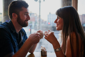 咖啡商店与充满深情的年轻的夫妇坐着咖啡商店日期