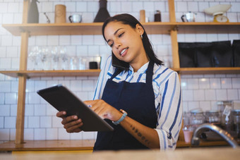 咖啡馆经理规划在线客户订单工作数字平板电脑互联网电话调用销售餐厅启动小业务老板女人企业家热情好客工人
