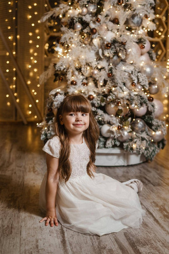 女孩节日光衣服礼物手圣诞节树灯花环背景概念一年假期