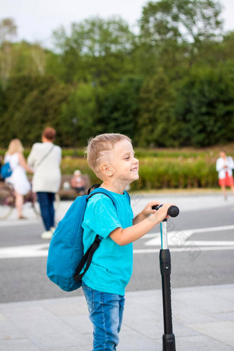 男孩踏板车路堤城市旅程背包回来脸表达自然快乐的情绪上演了照片生活