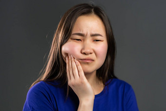 年轻的亚洲女人牙疼痛灰色工作室背景牙痛牙科<strong>问题口腔</strong>学医学概念