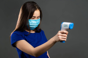 美丽的亚洲女人保护医疗面具电子<strong>温度</strong>计<strong>测量温度</strong>流感疫情科维德冠状病毒