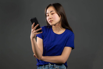亚洲年轻的女孩短信发短信应用程序智能手机漂亮的女人冲浪互联网移动电话灰色工作室