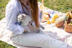 年轻的女人白色衬衫休息野餐宠物小猫