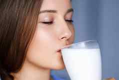 快乐年轻的女人喝牛奶蛋白质牛奶摇鸡尾酒健康的喝饮食健康