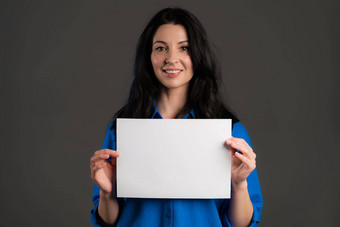 成熟的女人持有白色纸海报复制空间微笑时尚的夫人长头发工作室背景