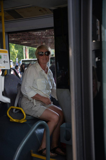 中年高加索人女人坐着公共汽车图片玻璃反射