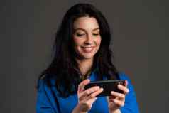 成熟的女人短信发短信应用程序智能手机漂亮的成人夫人冲浪互联网移动电话灰色工作室肖像