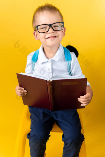 肖像有趣的学前教育孩子男孩大眼镜坐在椅子读取书黄色的<strong>背景</strong>快乐微笑孩子回来学校<strong>幼儿园</strong>成功动机天才超级英雄概念