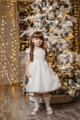 女孩节日光衣服礼物手圣诞节树灯花环背景概念一年假期