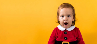 横幅portraite情感可爱的快乐的胖乎乎的婴儿女孩圣诞老人西装打哈欠唱歌橙色背景孩子圣诞节场景庆祝生日孩子有趣的花一年时间复制空间