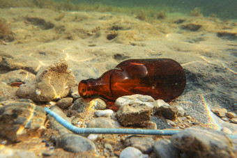小棕色（的）啤酒瓶蓝色的塑料稻草桑迪海底水下照片海洋乱扔垃圾概念