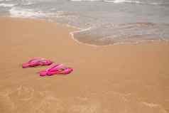 海滩粉红色的人字拖光沙子纹理光沙子概念海滩假期夏天概念平躺一边视图复制空间热带假期概念