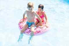 孩子们有趣的玩游泳池夏天假期