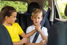 快乐孩子们可爱的蹒跚学步的女孩少年哥哥坐着现代车锁着的安全腰带享受家庭假期旅行夏天周末
