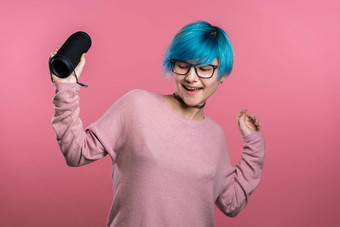 可爱的女人蓝色的头发微笑跳舞无线可移植的演讲者粉红色的工作室背景音乐跳舞概念