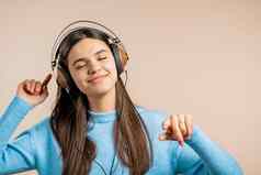 可爱的女人跳舞耳机光工作室背景可爱的女孩肖像音乐广播幸福自由青年概念