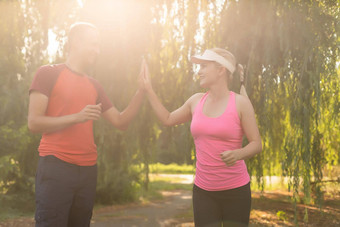 年轻的健康<strong>夫妇</strong>放松温暖的慢跑运行公园