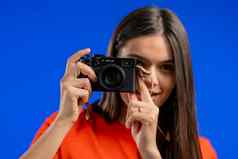 年轻的漂亮的女人需要图片数码单反相机相机蓝色的背景工作室女孩微笑摄影师