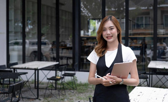 肖像美丽的千禧亚洲女女服务员餐厅老板站前面餐厅入口餐厅咖啡商店业务老板概念